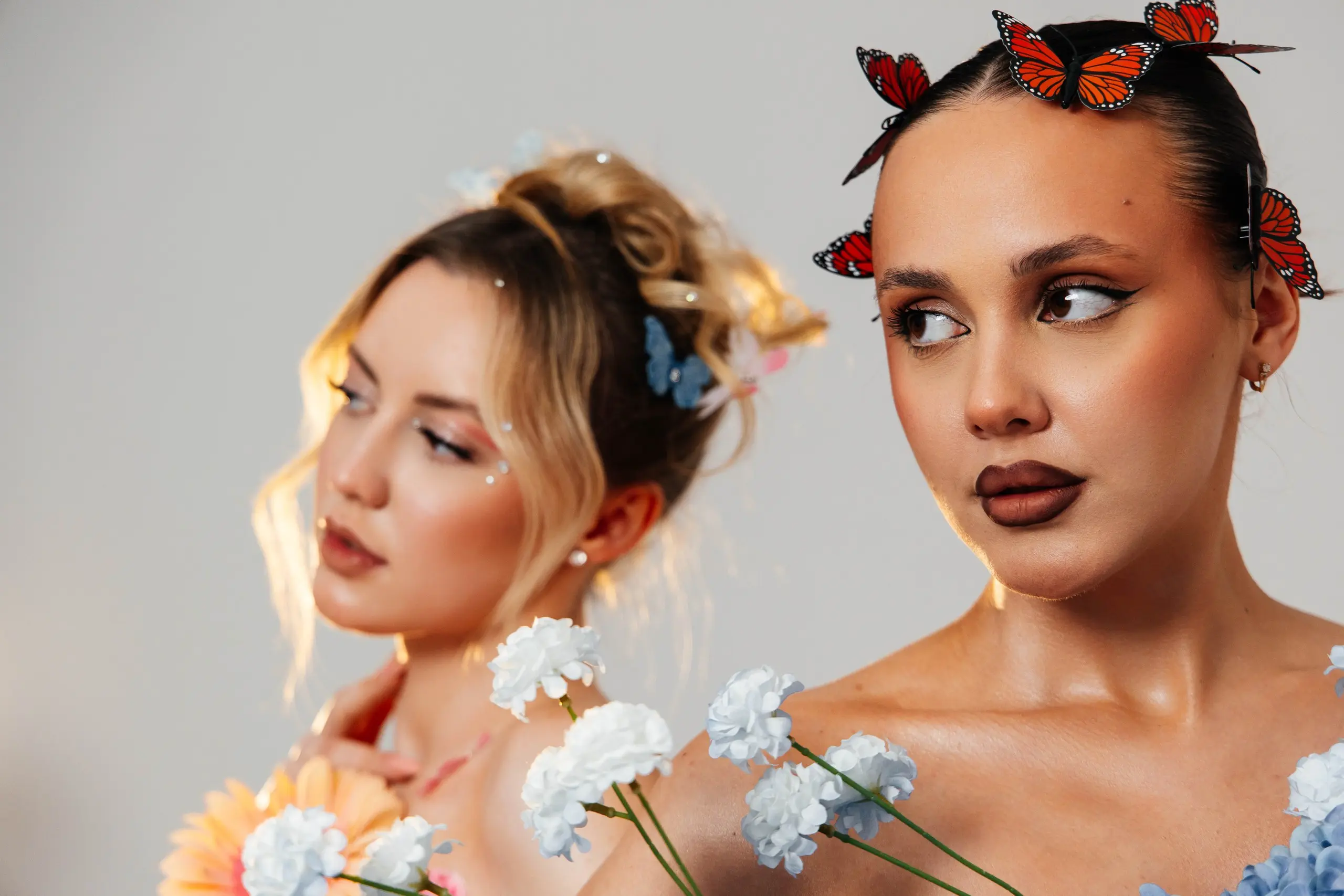 Dwa portrety beauty z motylami i kwiatami